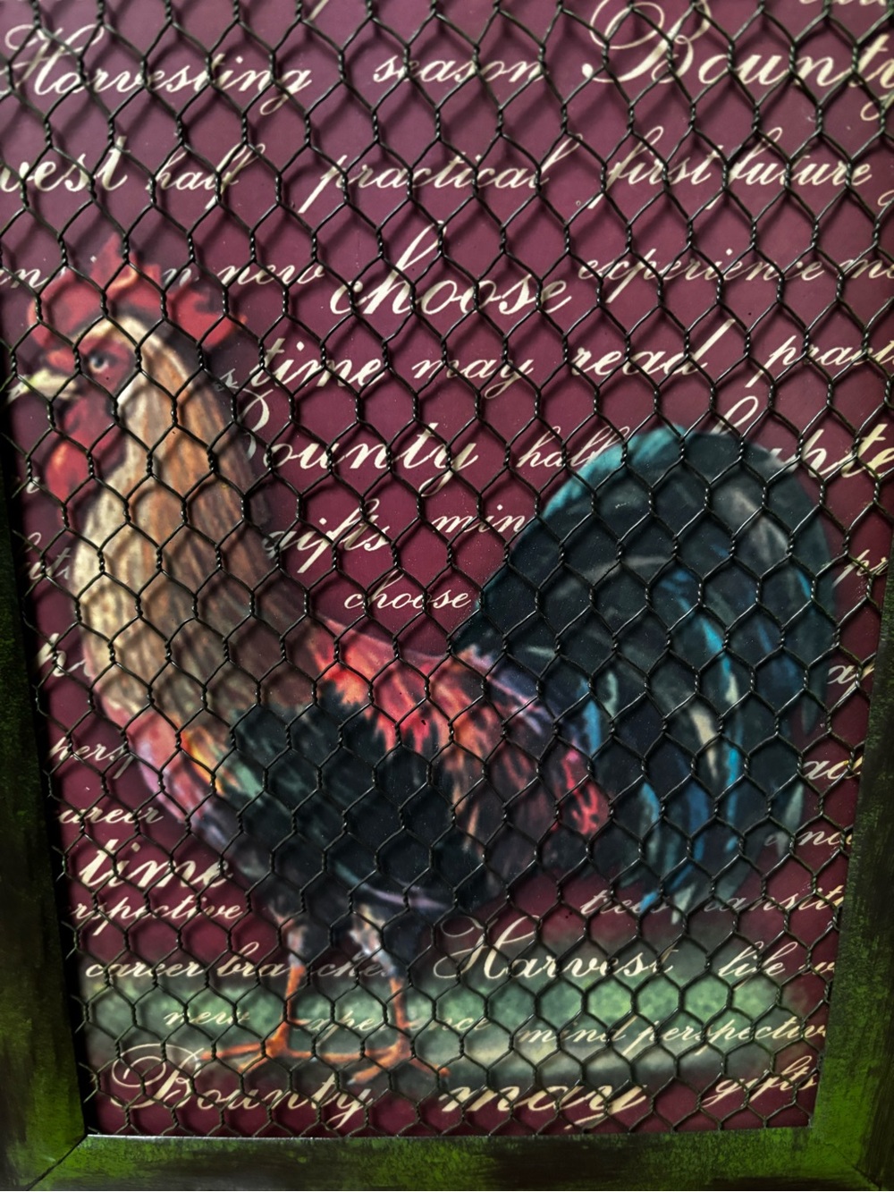 Rooster a rustic framed wall art piece behind chicken wire mesh.